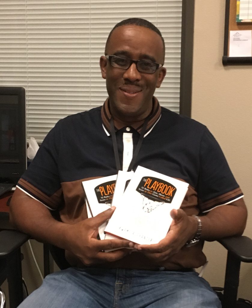 Coach Parker Holding Donated copies of The Playbook for his basketball team