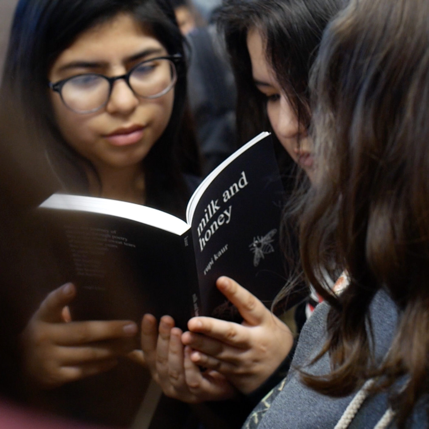 Teen girls sharing a poetry book