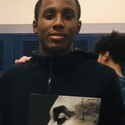 varsity basketball player proudly holding a Kobe Bryant book